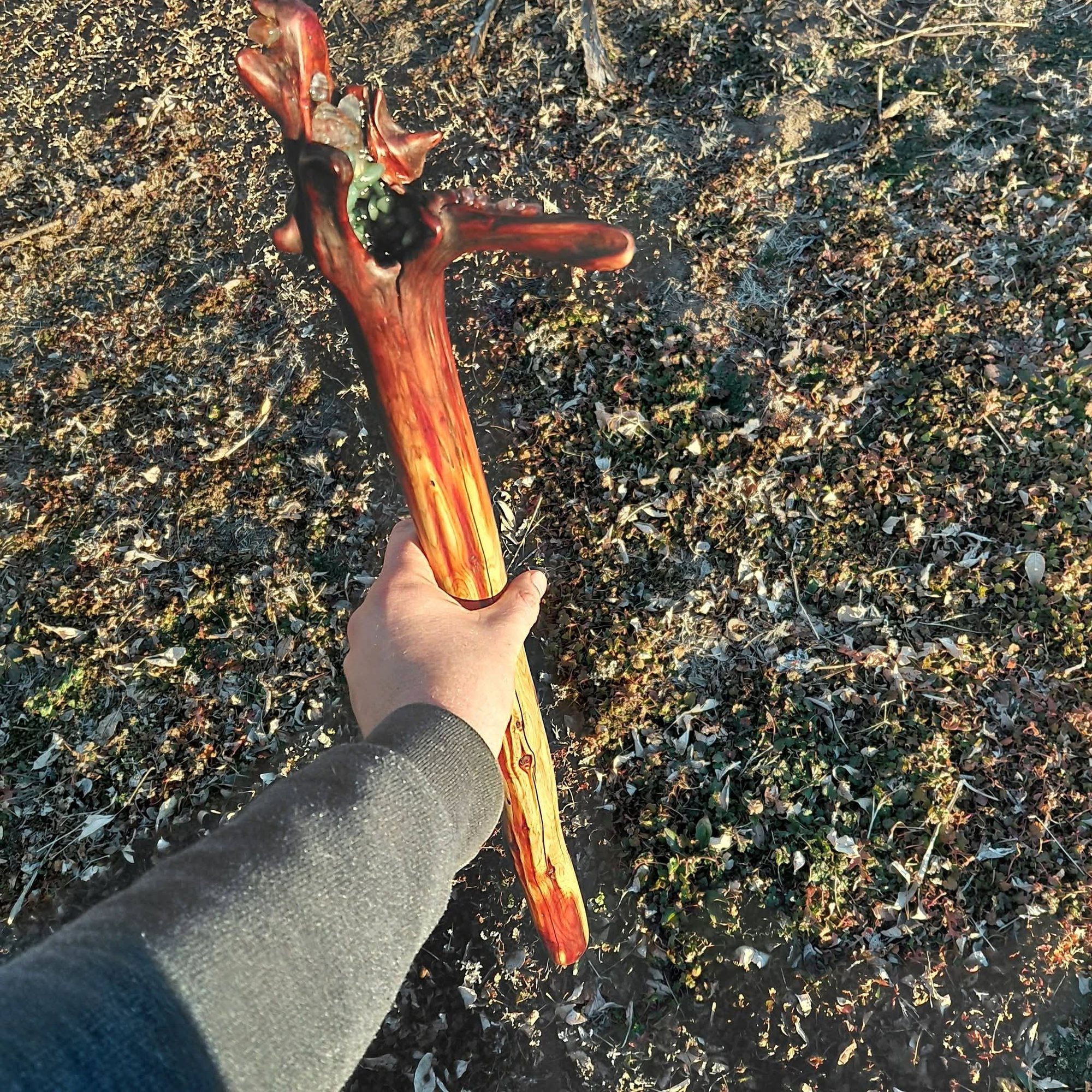 Eastern red cedar root staff held over Kansas ground, the root head set with green aventurine and quartz